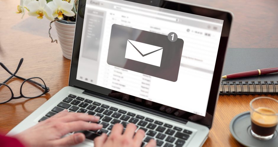 Email notification, woman hand on the computer laptop, one new inbox e mail message on the screen Email notification concept, woman working with a computer laptop, one new inbox e mail message on the screen, business office desk background